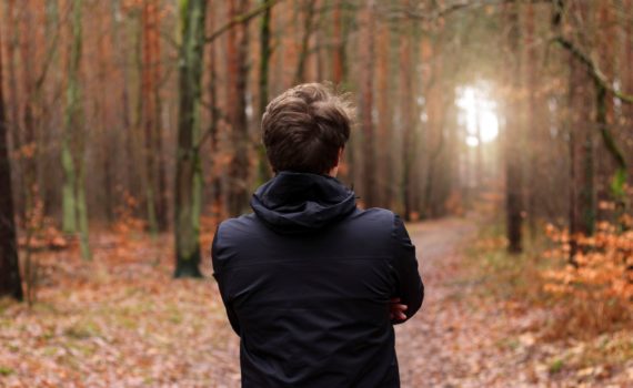 man standing in forest